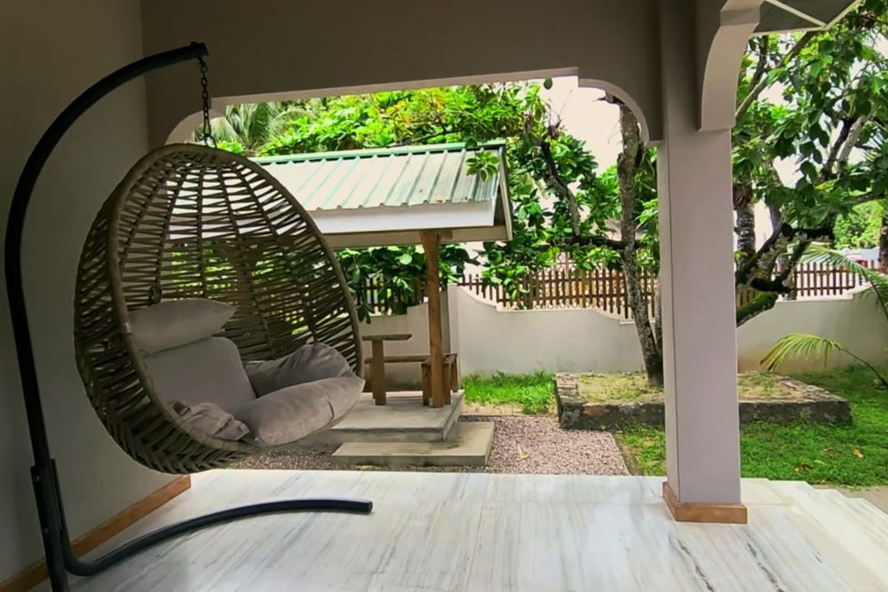 AliBel Beach Villa'da Avocado stüdyosunun verandasındaki salıncak koltuk