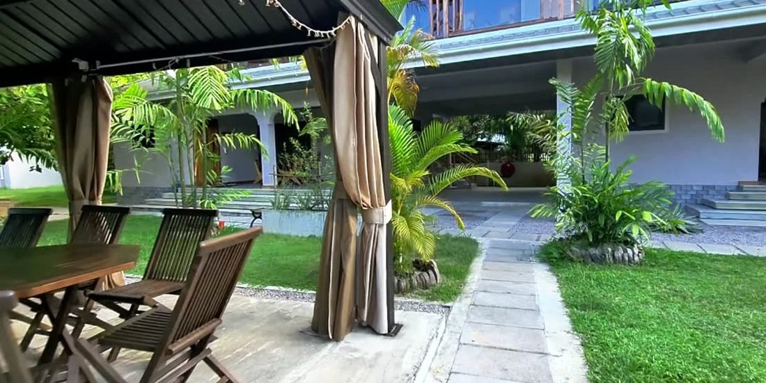 AliBel Beach Villa'da South aile villasının balkonu altındaki bahçe çardağı