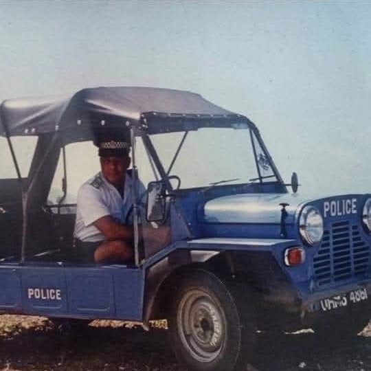 POLICE yazılı lacivert Mini Moke'un direksiyonunda bir polis memurunun arşiv fotoğrafı